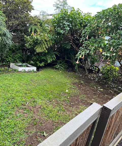 Enclosed yard with lots of veggie beds to grow your own food.