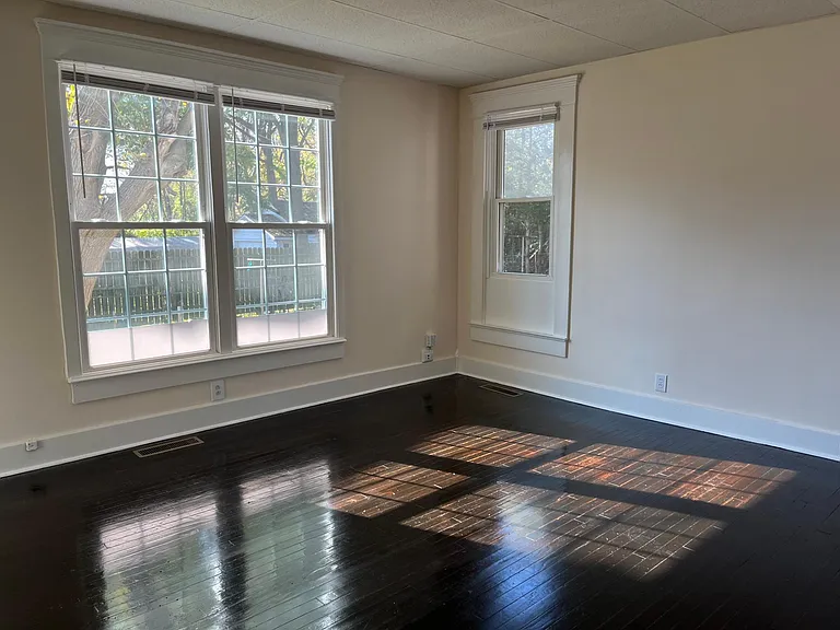 Inside your giant master suite with gleaming original hardwood floors, here is the spot for your desk. Look out over your lawn with beautiful trees.