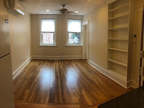 Livingroom with overhead fan, bright light from the windows overlooking Copp's Hill Burial ground, trees and green space. Mini-split A/C, heating combination.