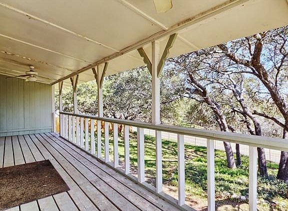 Large covered porch with serene view of mature trees.