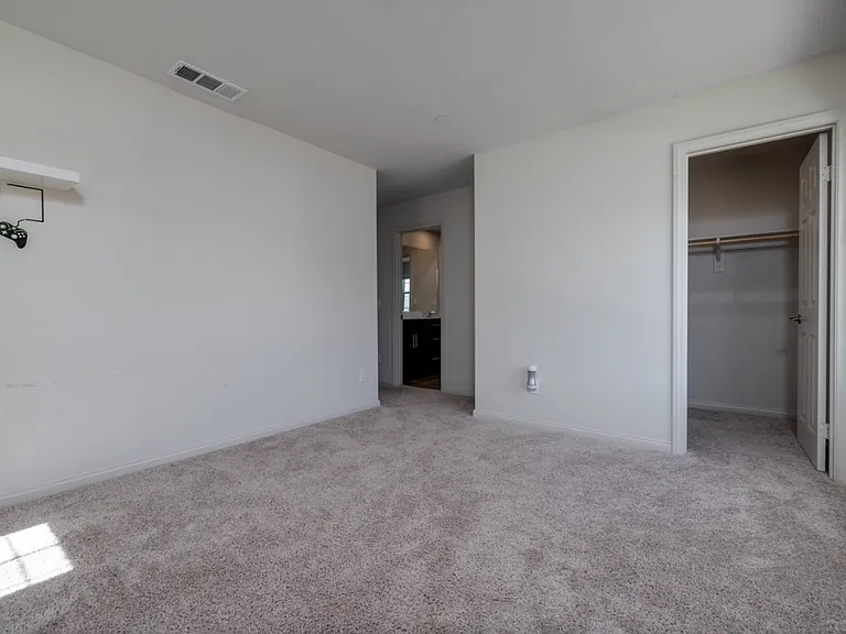 Bright first upstairs bedroom featuring direct access to the hallway, shared bathroom, and walk-in closet. East-facing windows invite beautiful morning sunlight, creating a warm and welcoming atmosphere perfect for a cozy start to each day.
