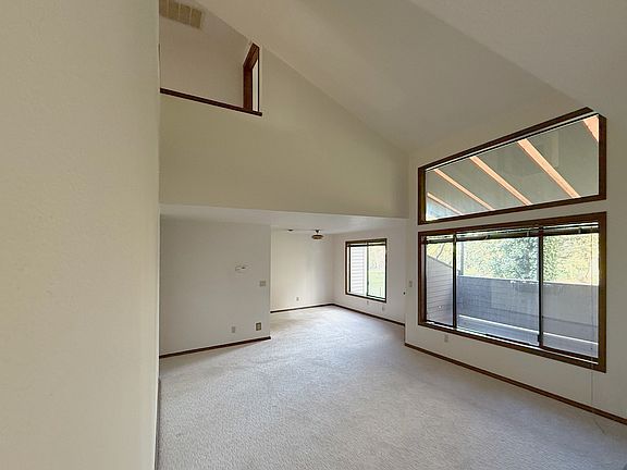 Bright open living room with vaulted ceilings, overlooking golf course.
