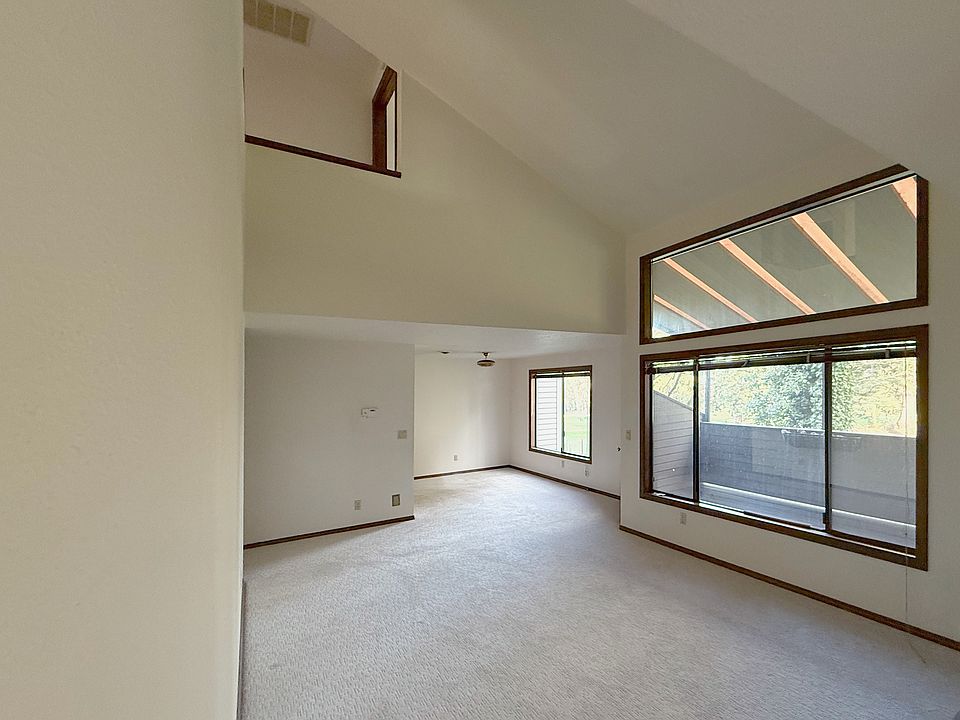 Bright open living room with vaulted ceilings, overlooking golf course.