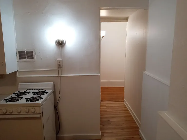 Hallway from kitchen. Bathroom on the left and the living room/bedroom beyond that.