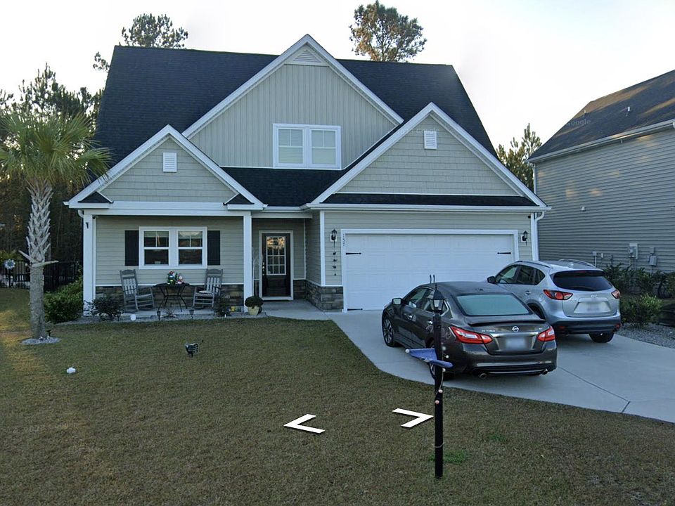 Front of home with two car garage and parking for two additional cars.
