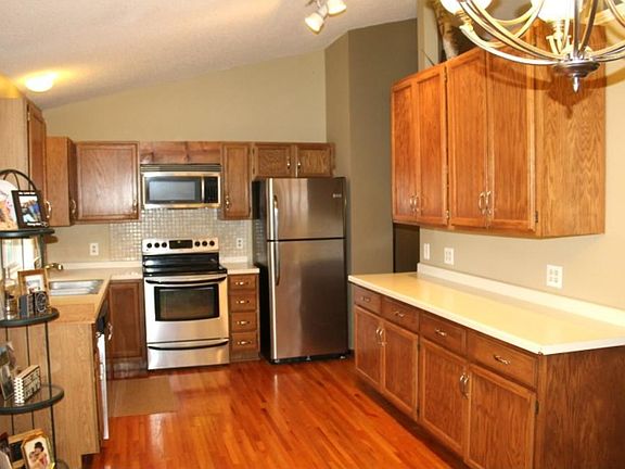 Large kitchen with vaulted ceilings and stainless appliances. An abundance amount of golden oak cabinets. Hardwood floors line the kitchen and dining area. Kitchen window over the sink provides a beautiful view of the back yard and fire pit area.