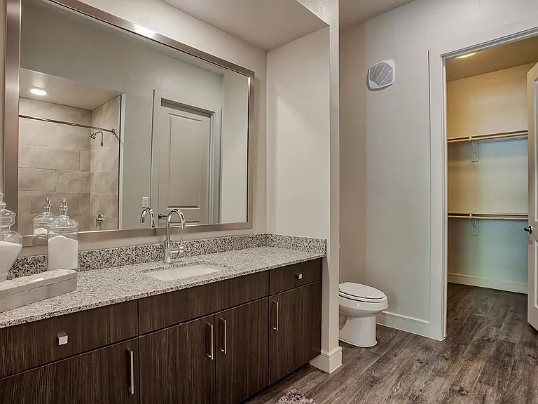 Granite counters, custom cabinetry and framed mirrors create a modern bathroom