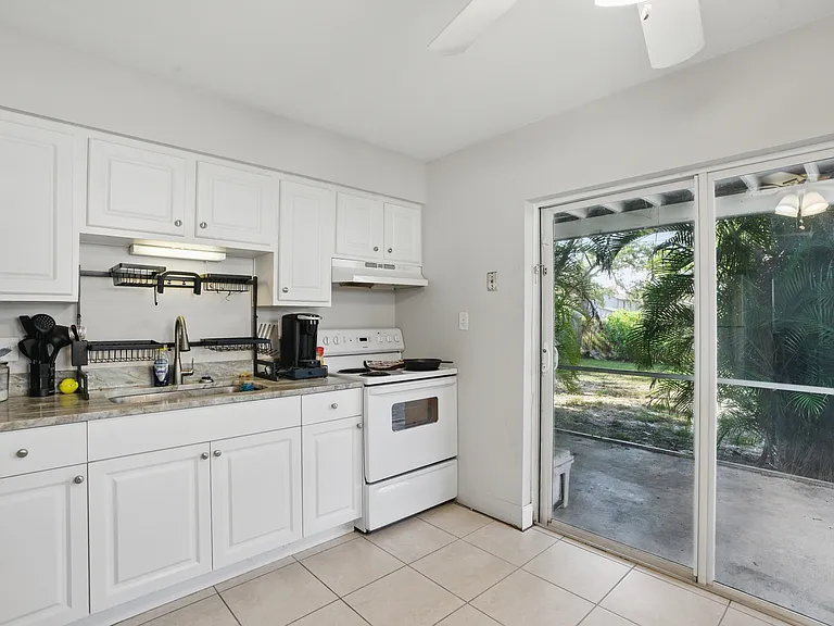 The kitchen is efficiently designed with modern cabinetry, ample counter space, and convenient access to the living and dining areas