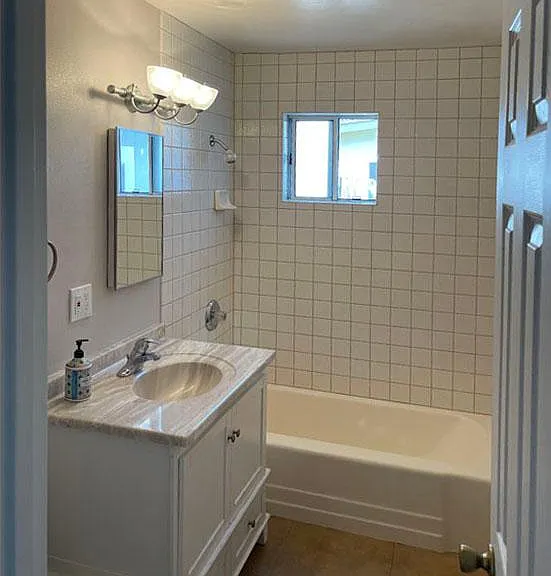 Bathroom. Fully tiled tub/shower to ceiling. Window for ventilation.