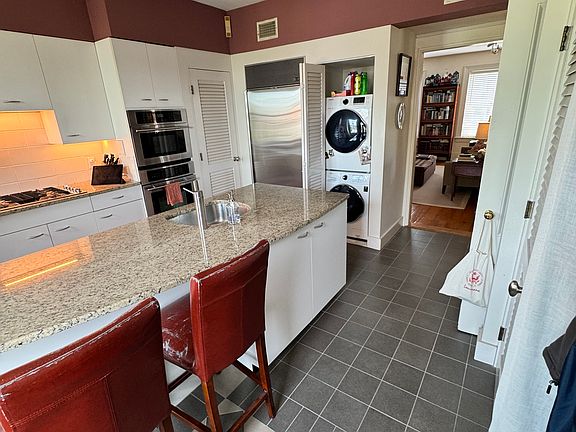 SubZero refrigerator and stacked washer/dryer