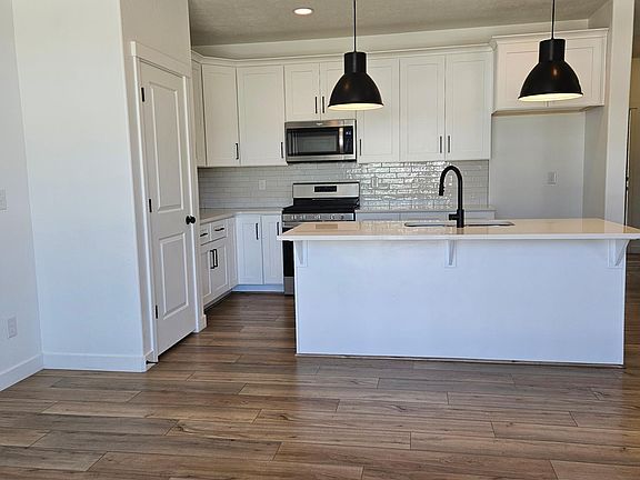 Kitchen with bar, dishwasher, gas stove, and built-in microwave.