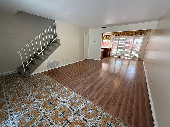 Bright, open living and dining space with large windows and plantation shutters