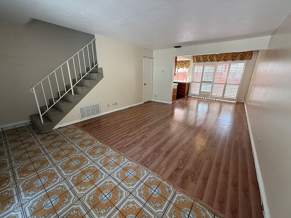 Bright, open living and dining space with large windows and plantation shutters