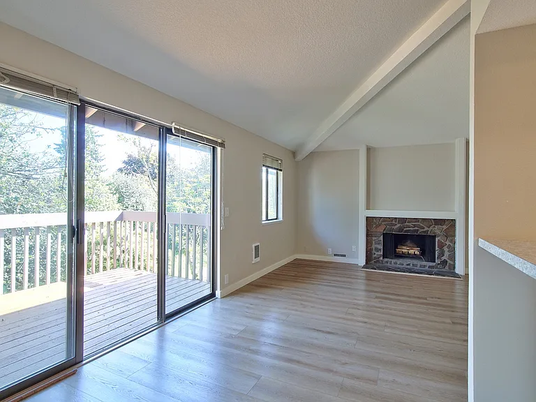 Open vaulted dining and living areas with wood burning fireplace to be enjoyed from any room. Large triple slider window onto the private deck.