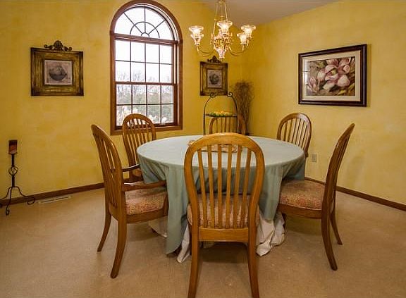 Formal dining room with vaulted ceiling and in-ceiling speakers for ambient sound during relaxing dinners with friends and family.