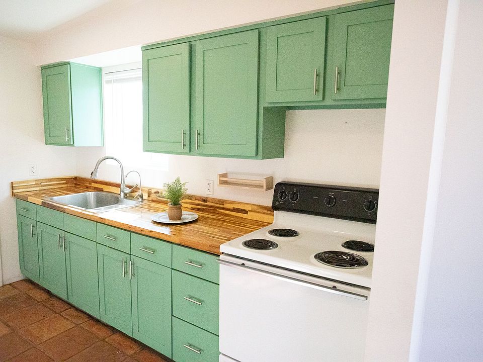 The kitchen features bright cabinetry and a warm butcher block countertop that creates an inviting workspace. The reverse osmosis system delivers clean, refreshing water straight from the tap, while the spacious layout offers room for a proper dining tabl