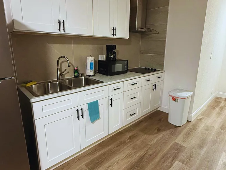 Complete kitchen featuring a stove, microwave, coffee maker and cabinetry.