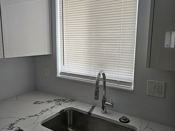 Large kitchen window. And, large sink with easy to use high faucet. Bold counter top design.
