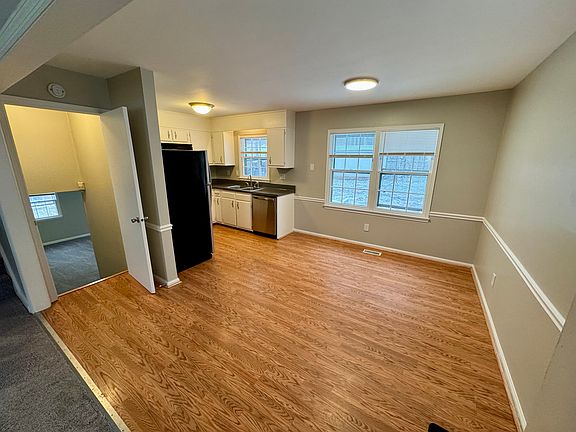 Dining area with kitchen and stairs to lower level on left.