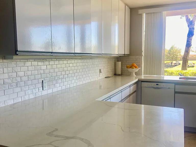 Newly renovated kitchen with quartz countertops , stainless appliances and views of the beautiful golf course and your private patio.