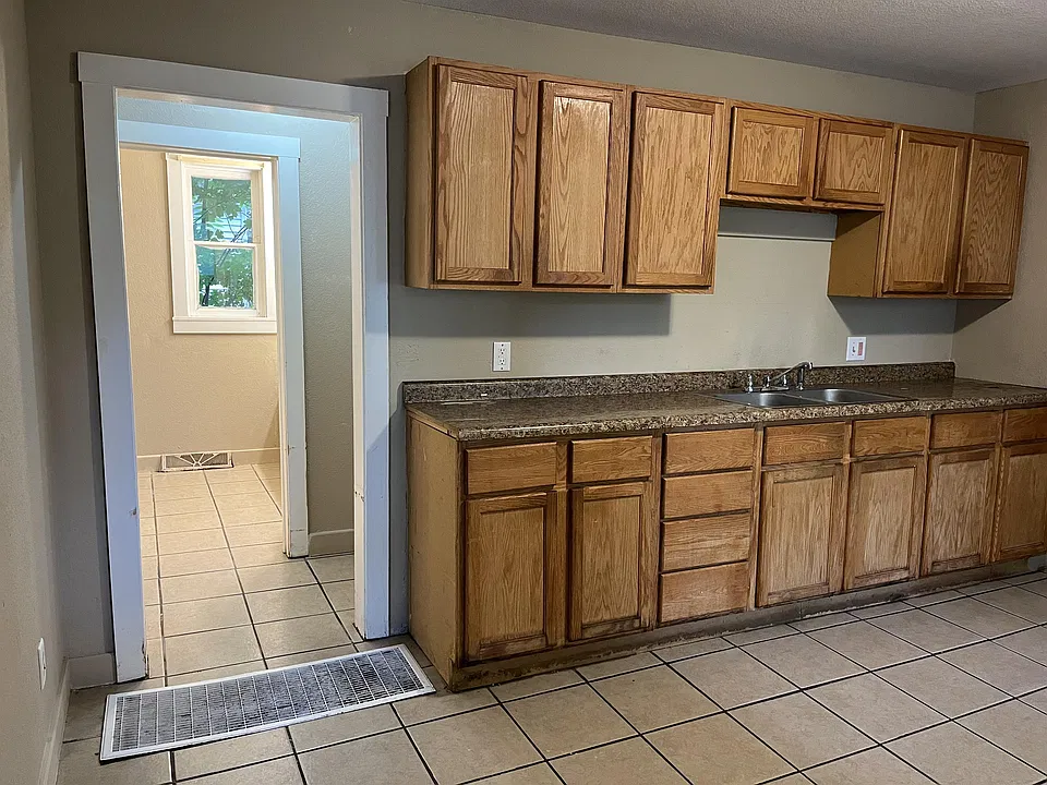 Kitchen view, looking into the bathroom with a hallway to a bedroom