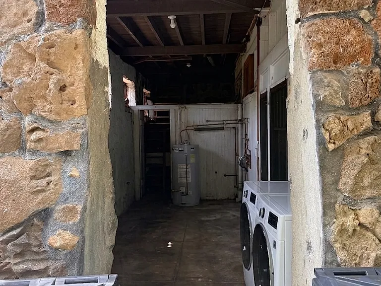 Covered laundry area with additional storage (to the left of the front door).