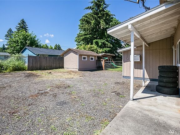 Backyard is cross fenced, with small building on this side of fence.