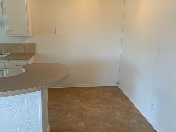 Dining area adjacent to kitchen with ceiling fan.