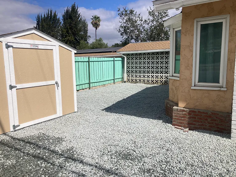 Hardscaping via gravel was added to protect from wildfires. The windows of he window seat can be seen in the center of the photo. The shed is a commercally built and installed lockable Tuff Shed