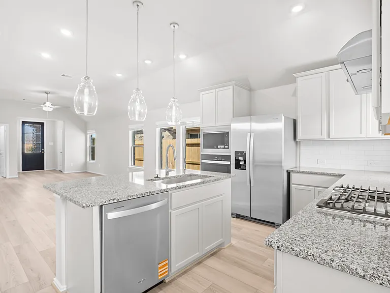 Large granite kitchen island with undermount sink and curved breakfast bar seating a?? ideal for casual dining and entertaining.