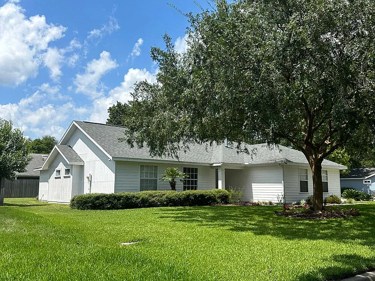Front View showing large corner lot with beautiful landscaping.