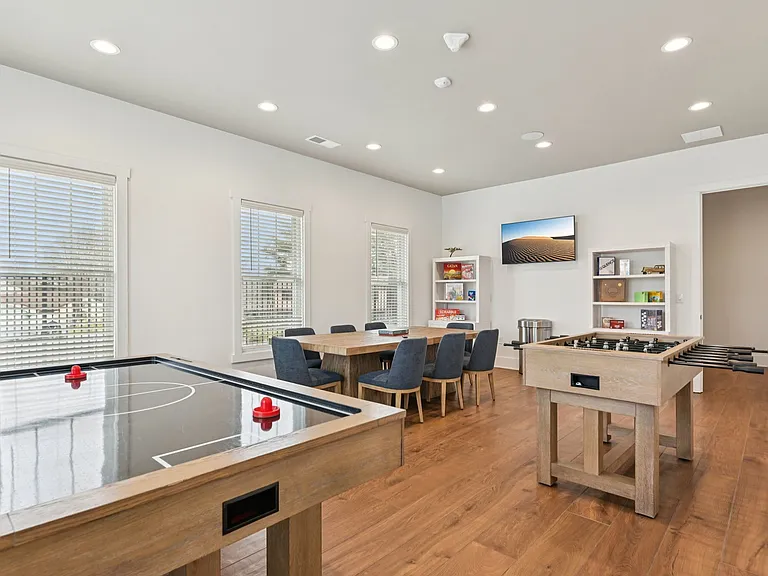 Get ready for some friendly competition in this bright game room, where air hockey, foosball, and cozy seating come together for the ultimate hangout spot.