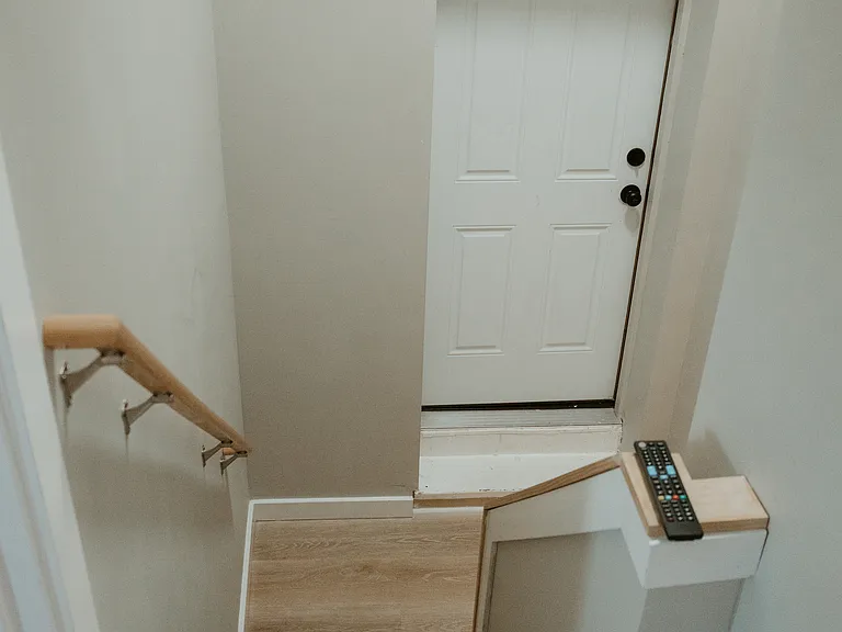 staircase with door leading to shared laundry room
