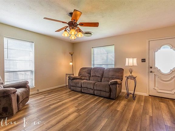 View of living room back to the front door. Home has been recently updated with laminate wood flooring throughout.