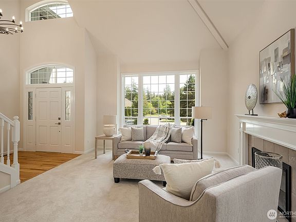 View from the living room to the dramatic entry featuring a designer entry light fixture!>