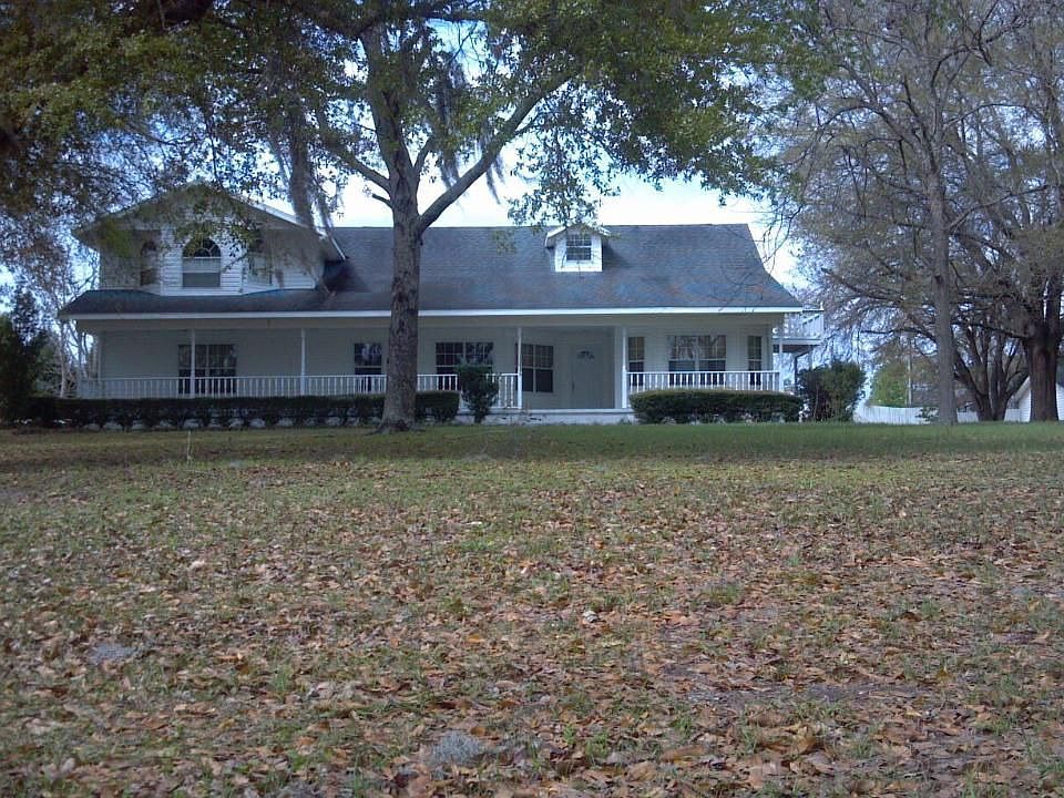 Exterior of home features large front porch and dormers.