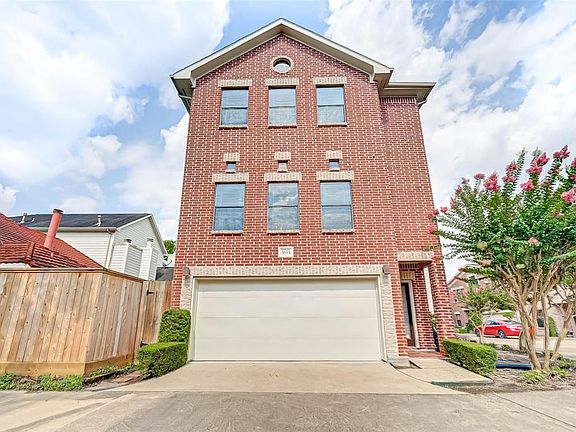 Brick home in gated community. Lots of windows and a two-car garage.