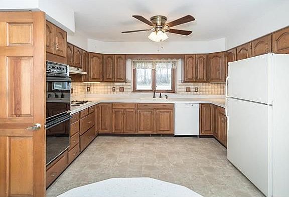 Solid Surface Neutral Countertop, ceramic Backsplash, Electric Cooktop and double wall oven.