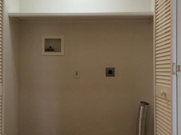 Laundry, lighted with shelf and bifold doors in hallway