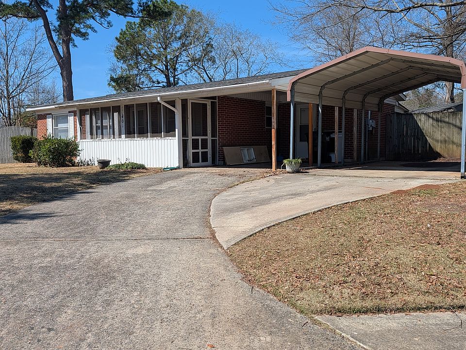 Front of house. Covered porch, double carport.