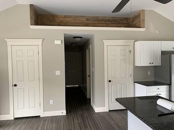 Side of kitchen and family room, hallways leads to three bedrooms and full bath