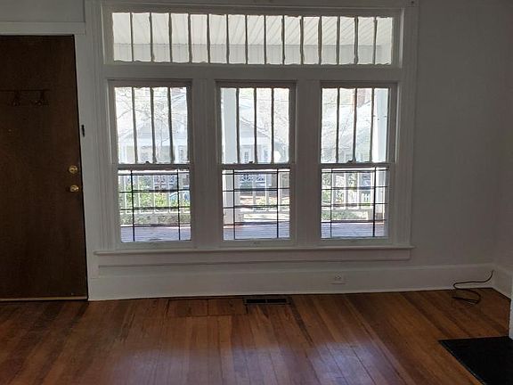 living room with fireplace, classic trim, lots of windows, hardwood floors