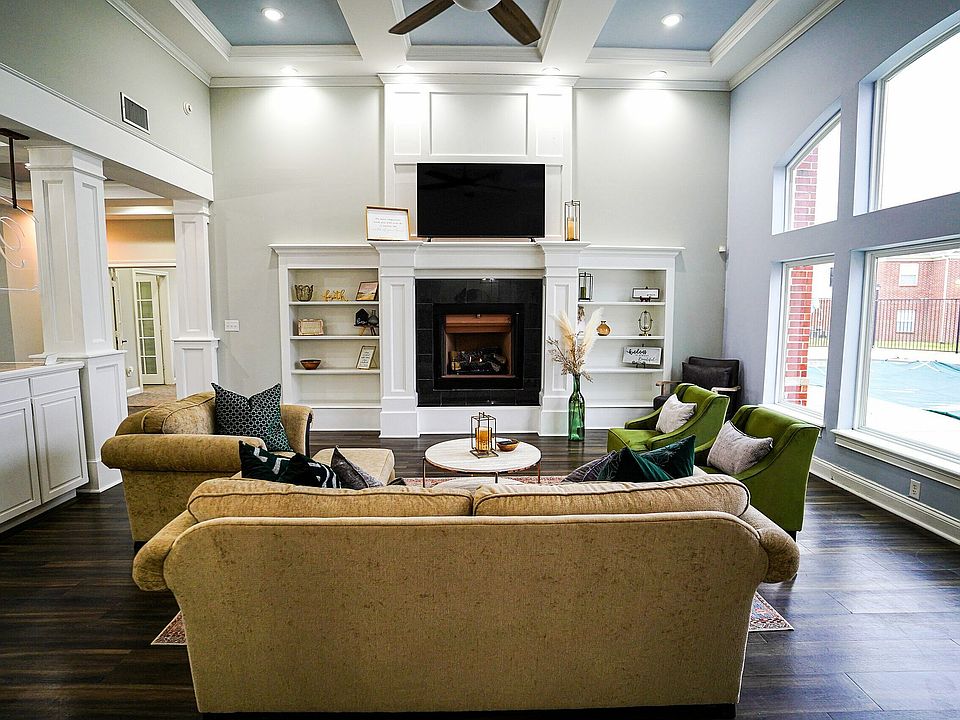 Kick back and connect in the bright and inviting resident lounge at The Bristol, featuring cozy seating, a fireplace, and views of the outdoor pool.