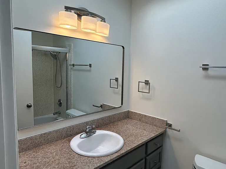 Bathroom updates include: new vanity lights, hardware, towel bars and mirror all with a brushed nickel trim. Vanity has been freshly painted in modern dark grey shade.