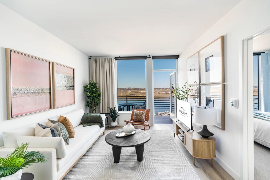 Open living with clean finishes, soft light, and direct access to a private balcony.