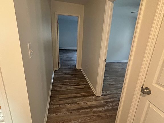 Hallway looking at the primary bedroom (far open door), the second bedroom (open door), and linen closet (closed door)