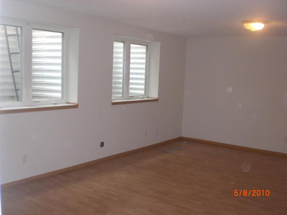 Open layout living room with three large egress windows.