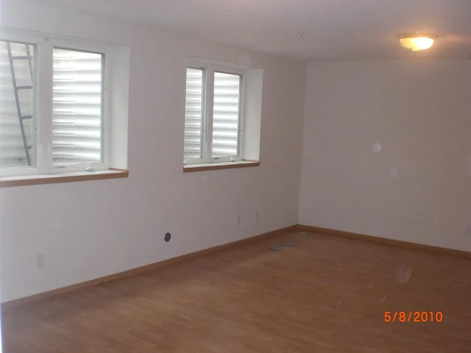 Open layout living room with three large egress windows.