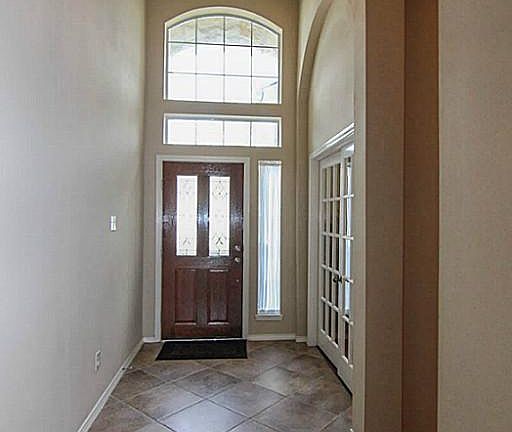 The entry features elegant lighting and tile floors set on diagonal.