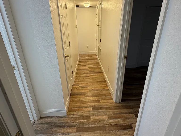 Upstairs hallway (from front bedrrom towards primary bedroom. Upstairs bathroom is left, third bedroom is on the right)